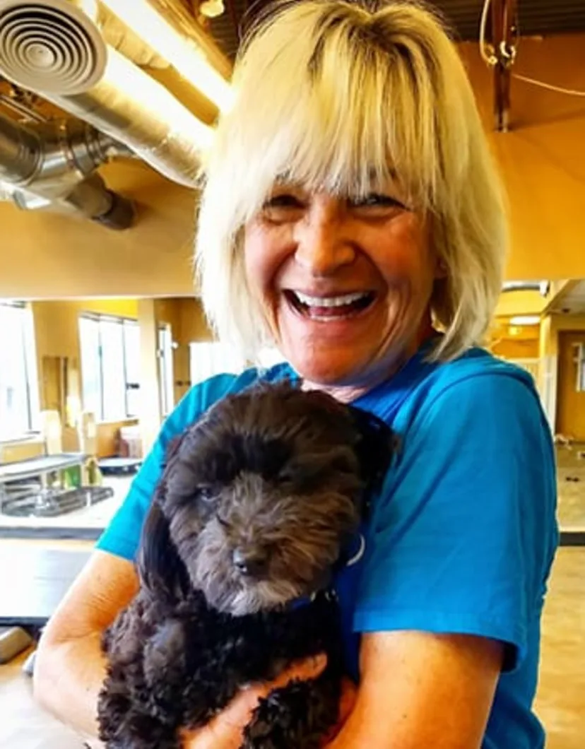 Suzi holding a puppy at Tiny Town small dog daycare in Boulder, CO